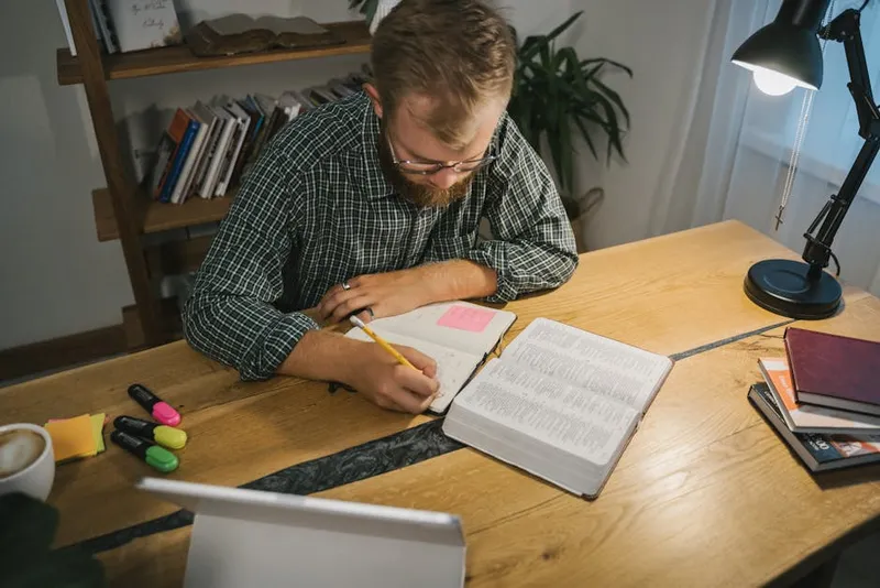 person focused studying notes notebook desk